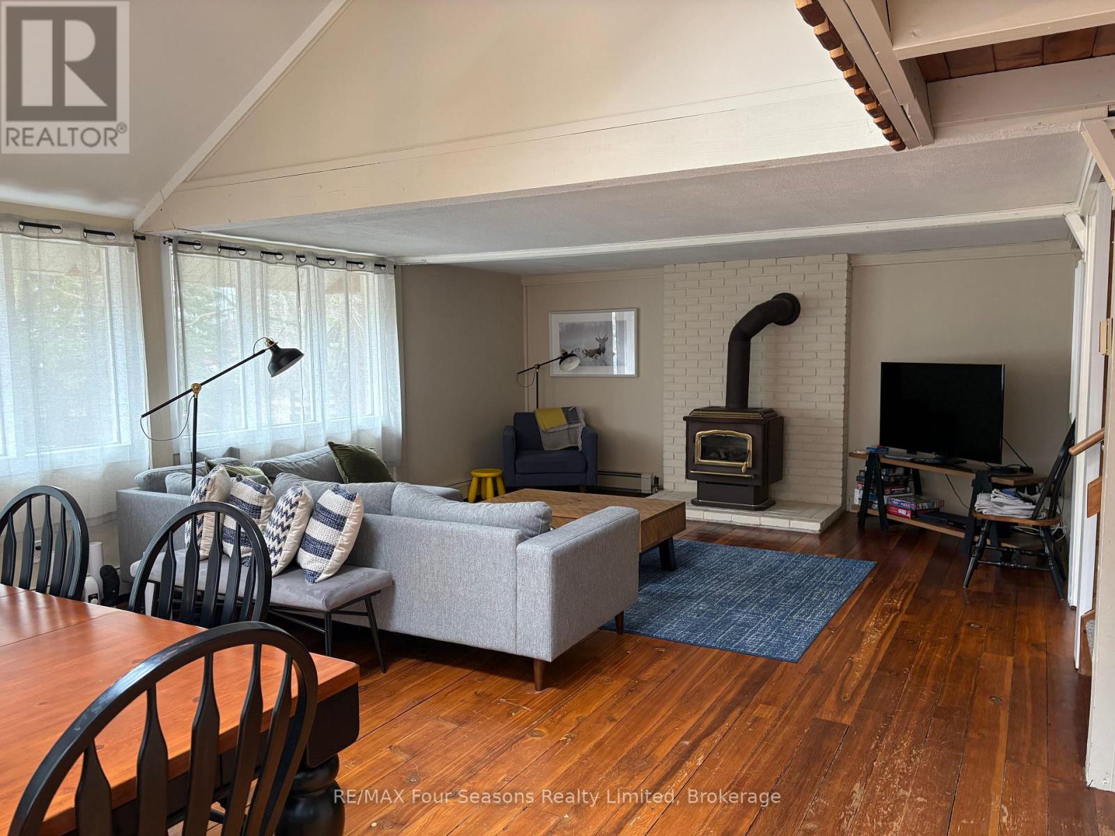 A living room with a grey couch and a fireplace.