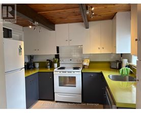 A kitchen with a white refrigerator, a white stove, and a yellow counter.