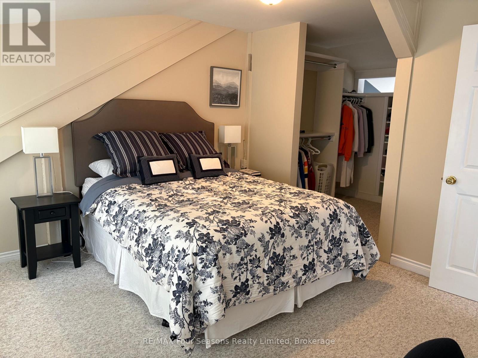A bedroom with a large bed and a closet.