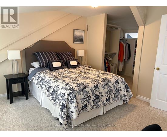 A bedroom with a large bed and a closet.