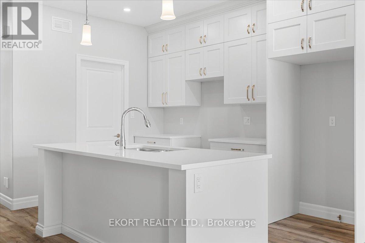 A white kitchen with a sink and cabinets.