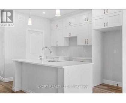 A white kitchen with a sink and cabinets.