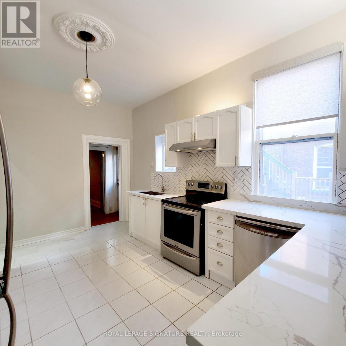 A kitchen with white cabinets and appliances.