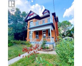 A red brick house with a white porch.
