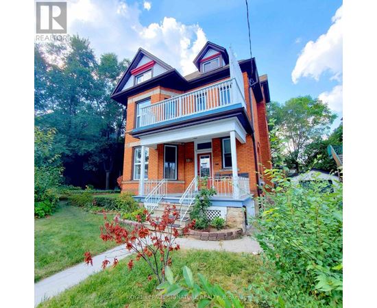 A red brick house with a white porch.