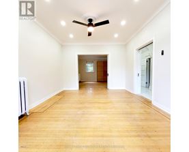 A room with a ceiling fan and wooden flooring.