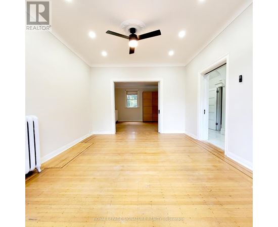 A room with a ceiling fan and wooden flooring.