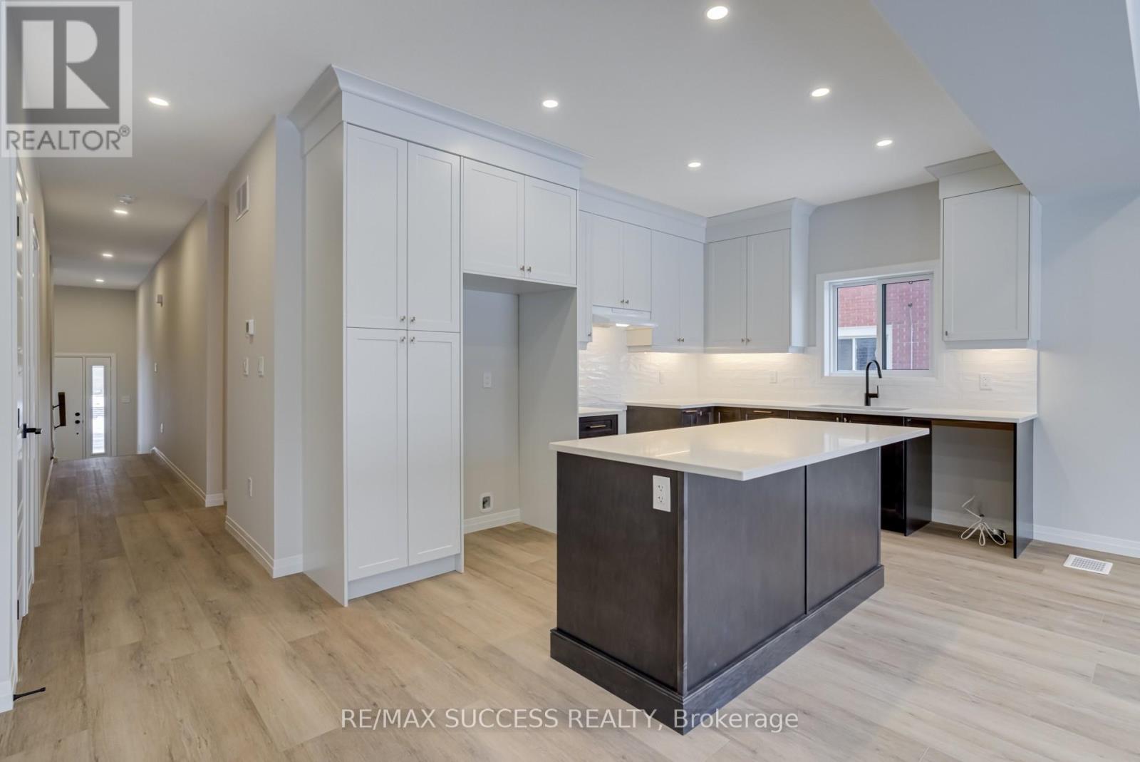 A modern kitchen with white cabinets and a dark island.