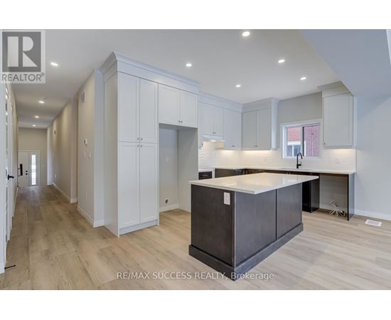 A modern kitchen with white cabinets and a dark island.