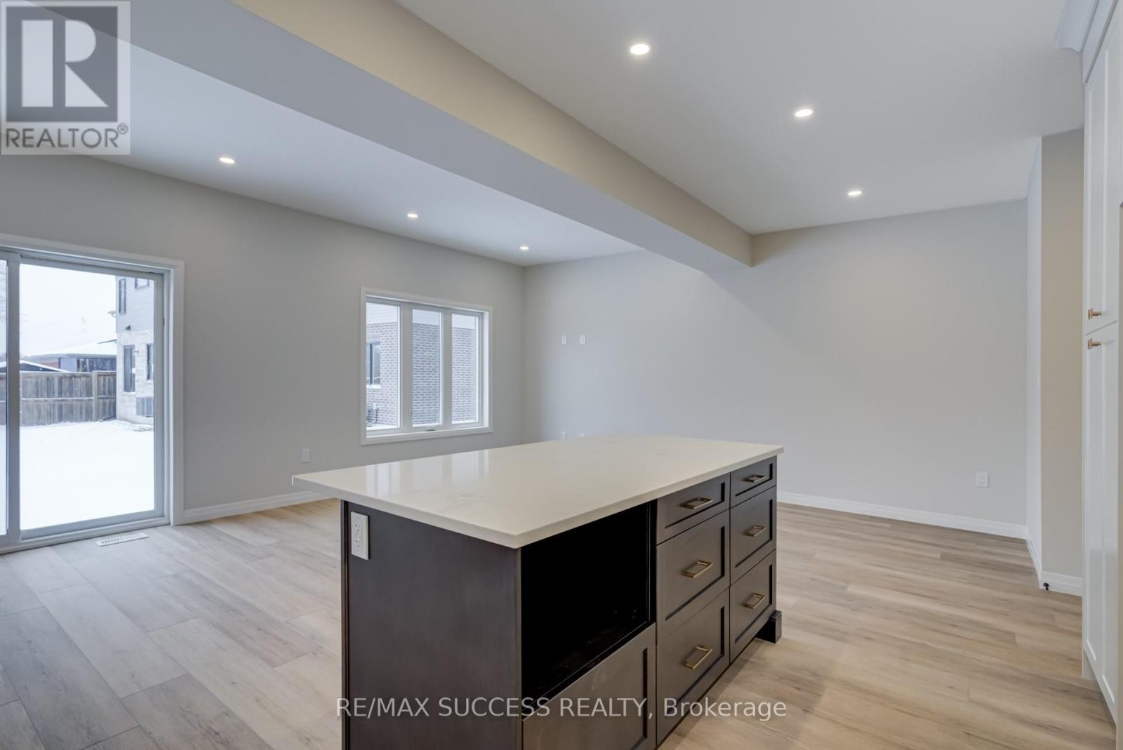 A spacious room with a large island in the middle and wooden flooring.