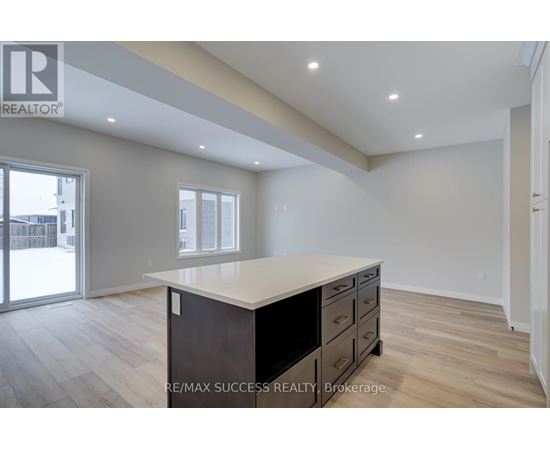 A spacious room with a large island in the middle and wooden flooring.