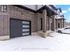 A building with a black garage door and a white car parked in front.