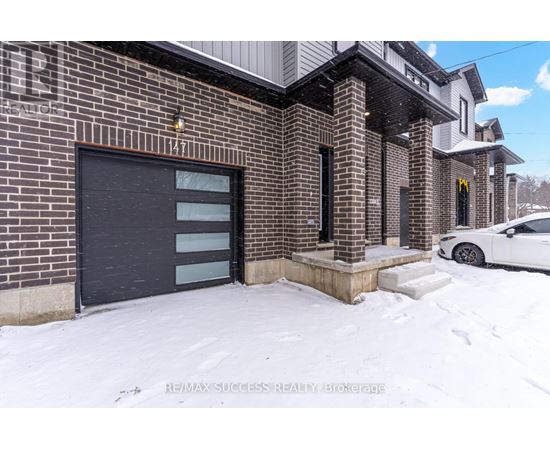 A building with a black garage door and a white car parked in front.