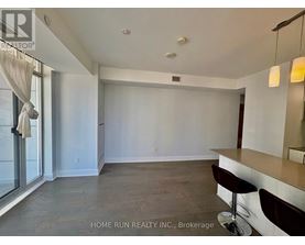 A spacious room with a bar area and a window with curtains.