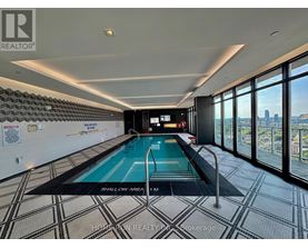 A swimming pool in a room with a tiled floor and a wall of windows.