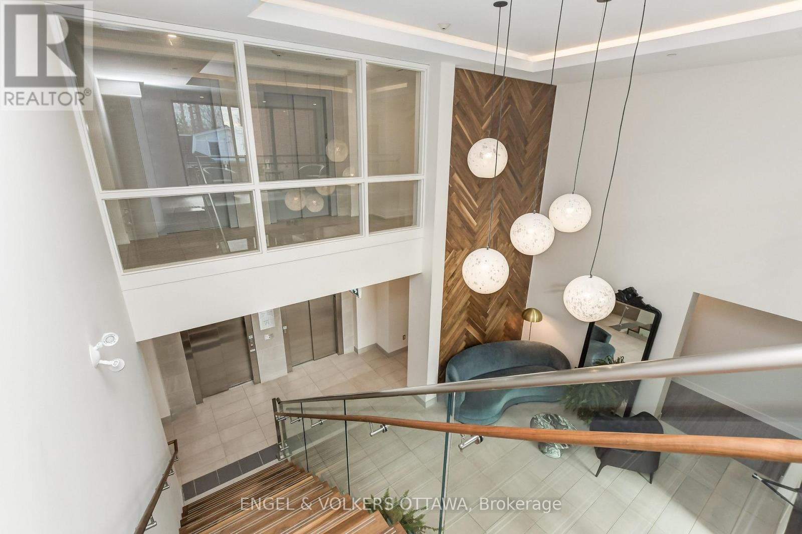 A modern interior space with a staircase and hanging lights.
