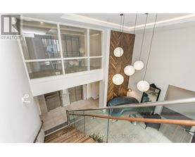 A modern interior space with a staircase and hanging lights.