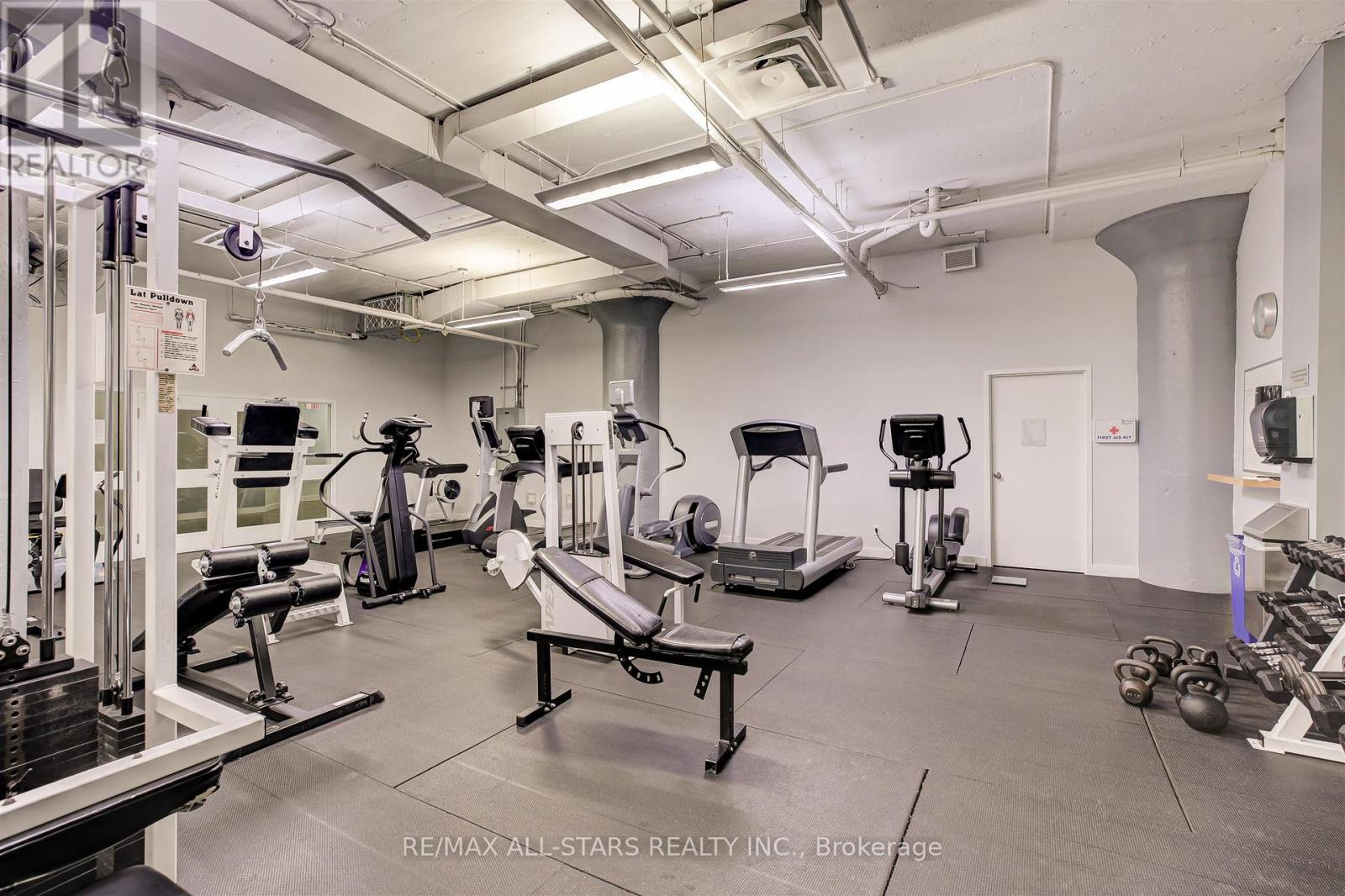 A gym with a variety of equipment including weights and cardio machines.