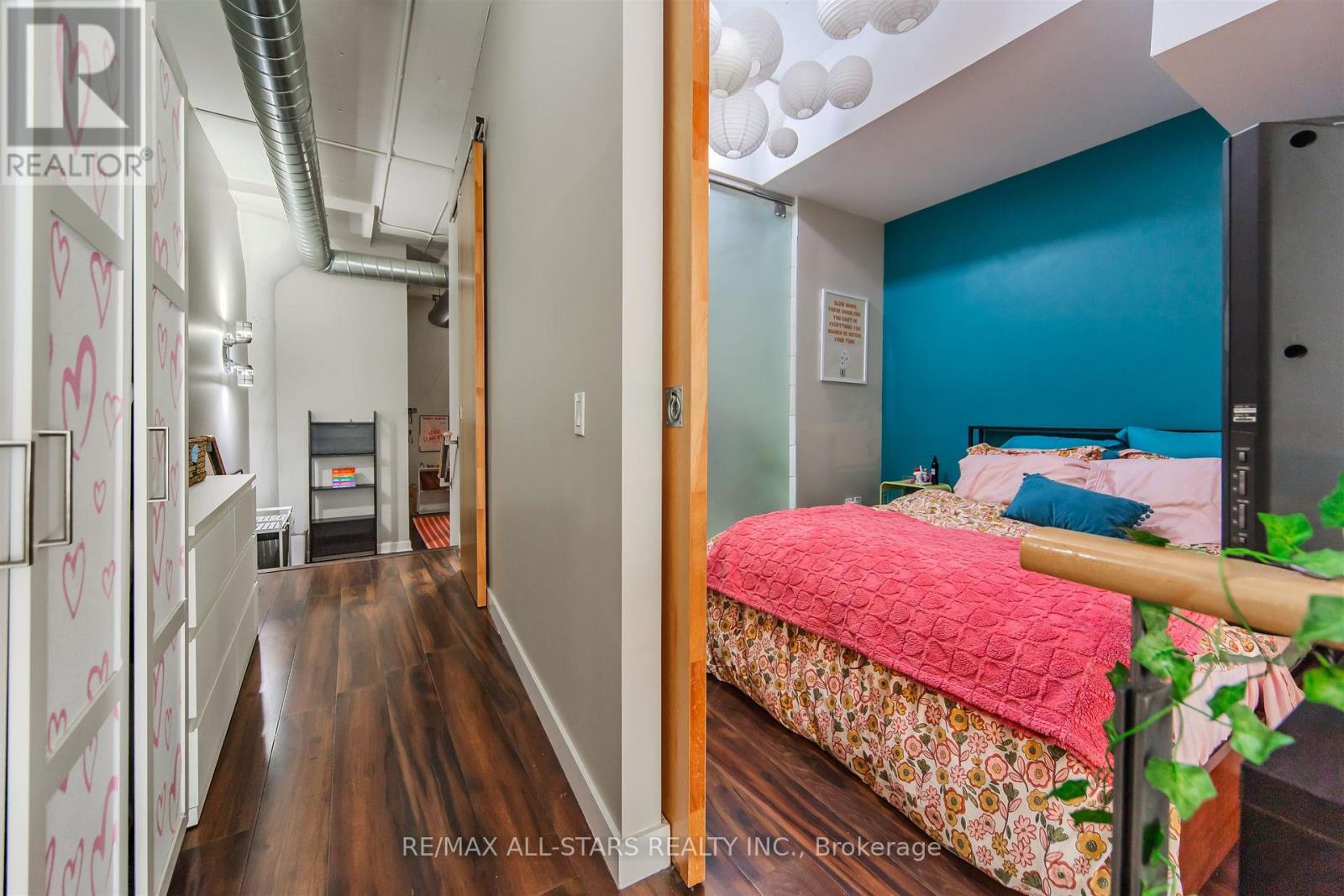 A bedroom with a bed and a pink bedspread.