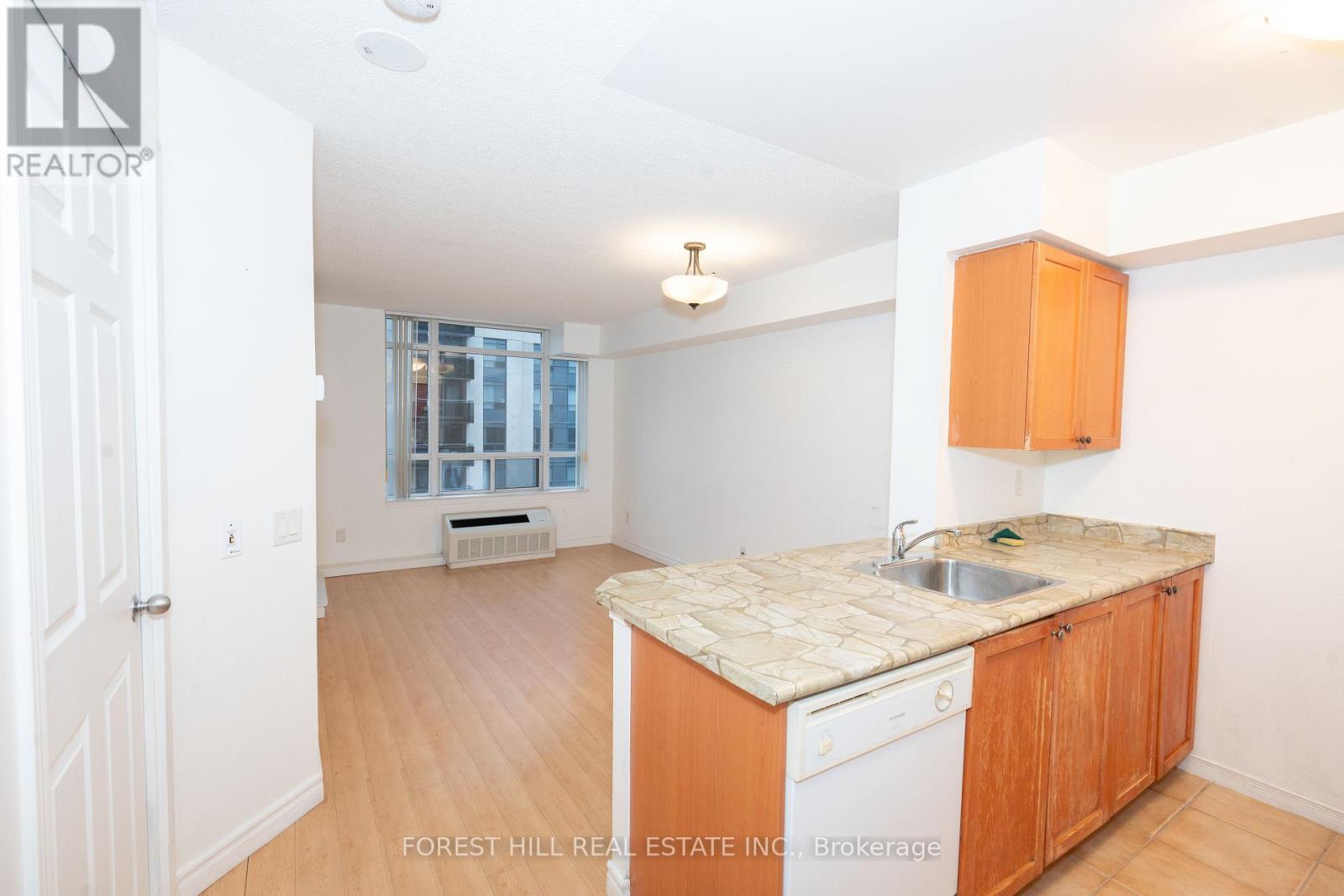 A kitchen with wooden cabinets and a marble countertop.