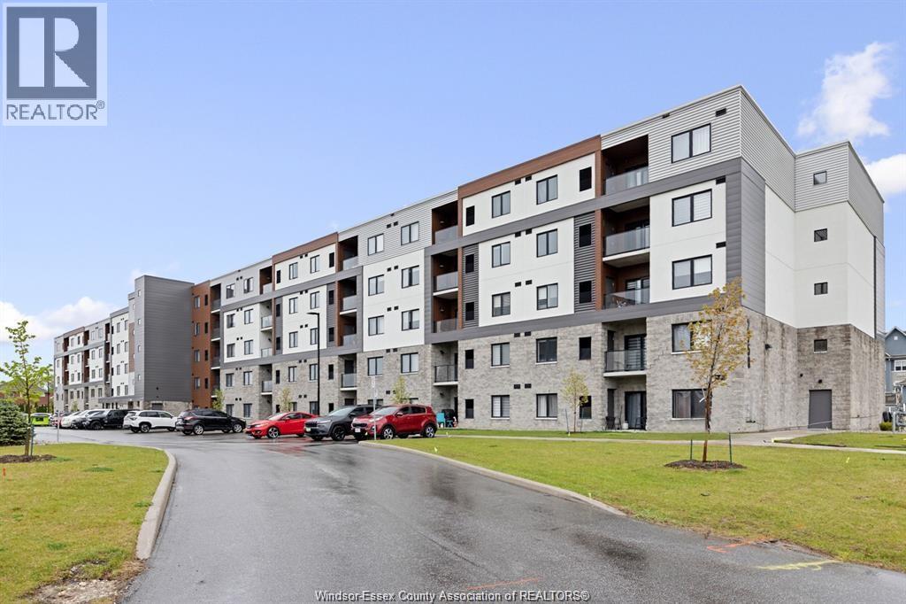 A large apartment complex with a parking lot in front.