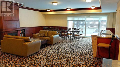 A living room with a brown leather couch and a patterned carpet.