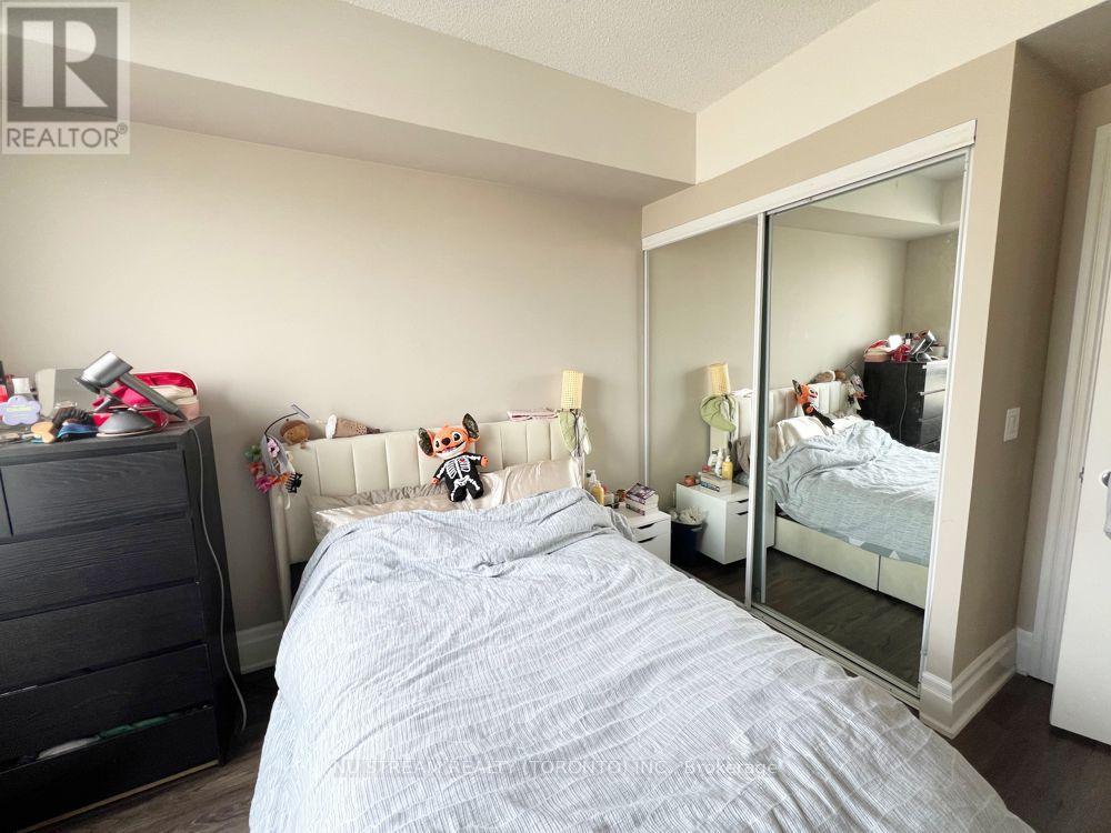 A bedroom with a large bed and a dresser.