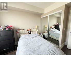 A bedroom with a large bed and a dresser.