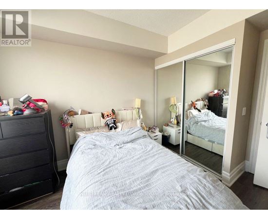 A bedroom with a large bed and a dresser.
