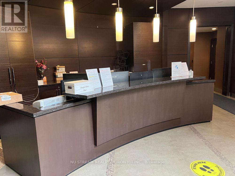 A reception desk with a sign that reads "REALTOR" and a logo on the floor.