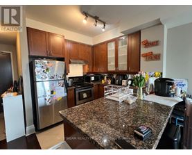 A kitchen with granite countertops and a refrigerator with magnets on it.