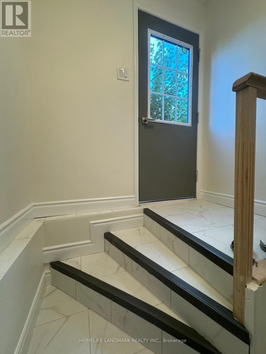 A staircase with a wooden railing and black treads.