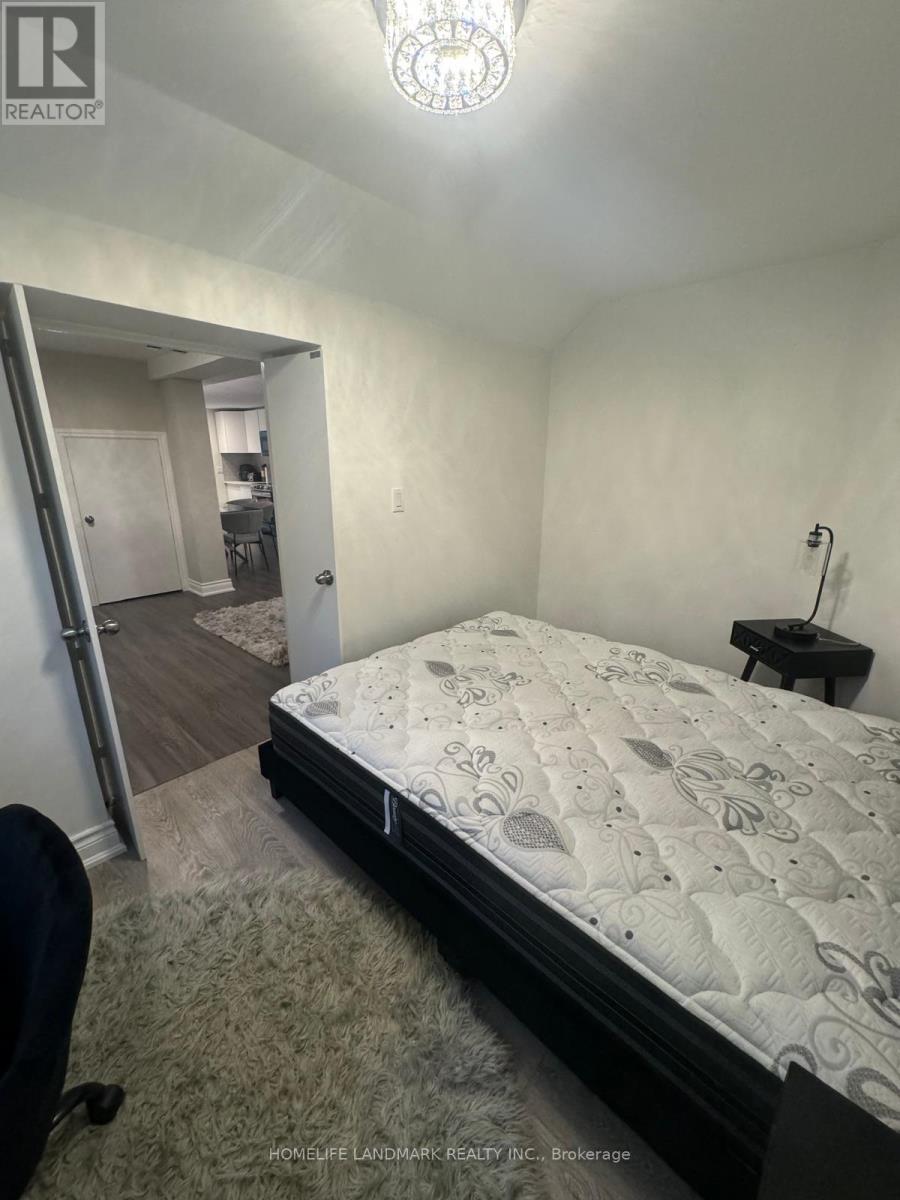 A bedroom with a large bed and a chair.