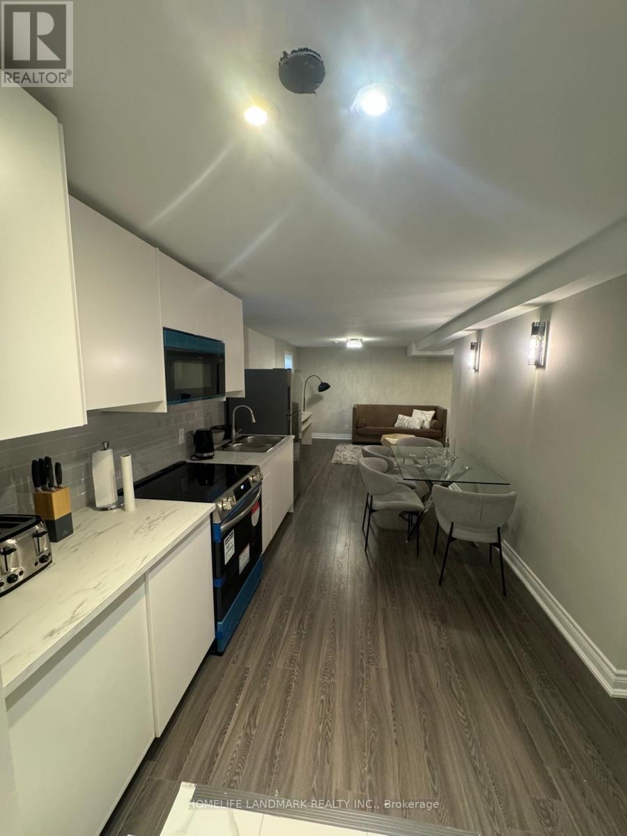 A modern kitchen with white cabinets and a dining table.