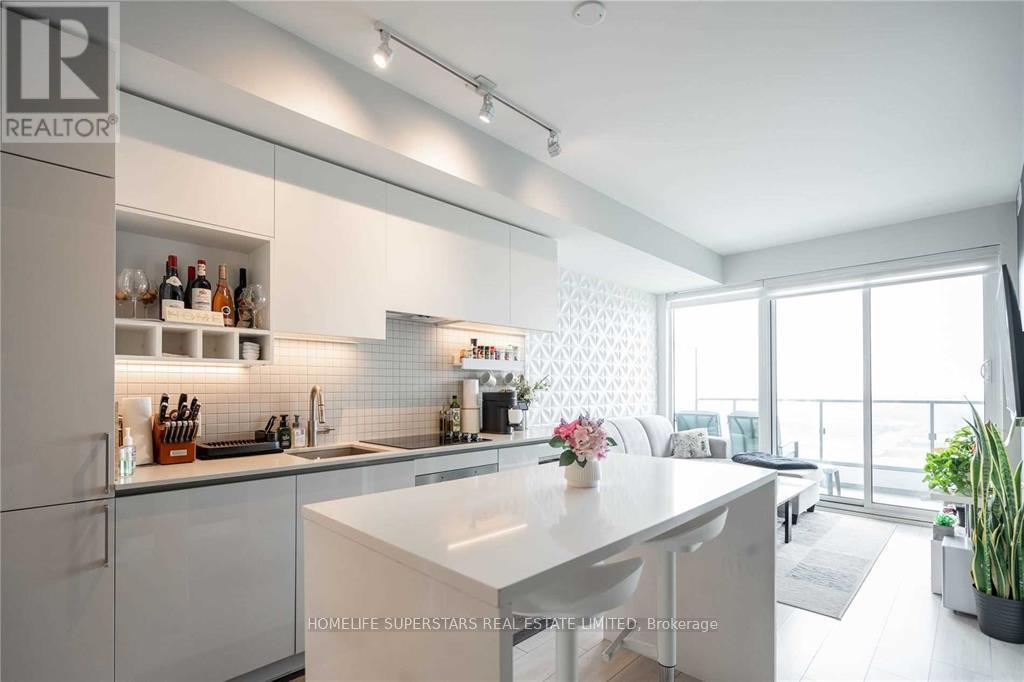 A modern kitchen with white cabinets and a large island.