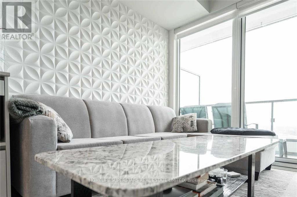 A modern living room with a grey sofa and a glass table.