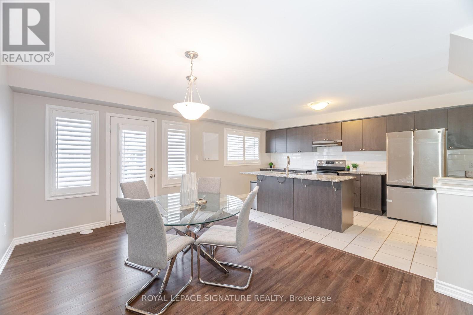 A well-lit kitchen with a dining table and chairs.