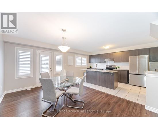 A well-lit kitchen with a dining table and chairs.