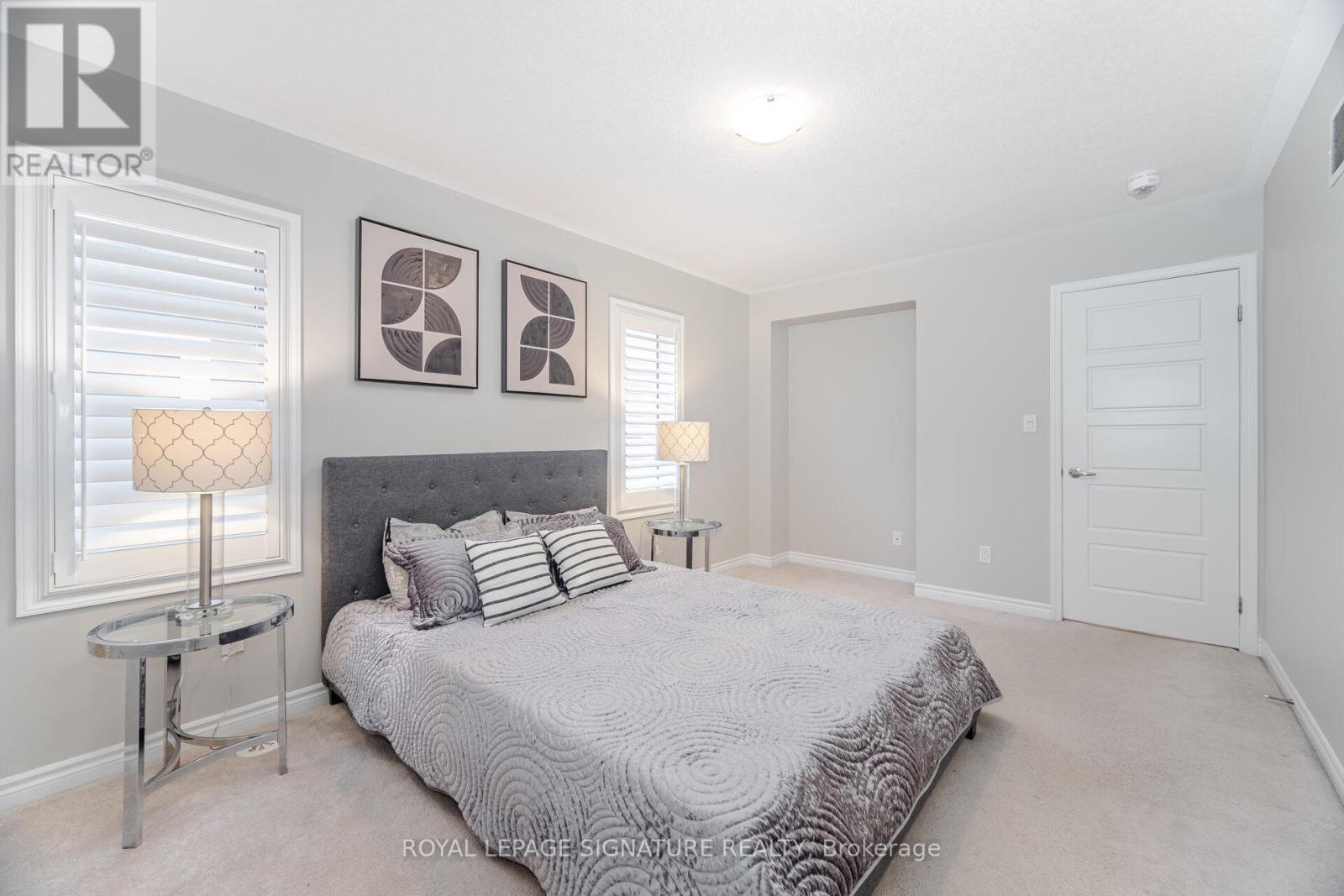 A bedroom with a large bed and two lamps.
