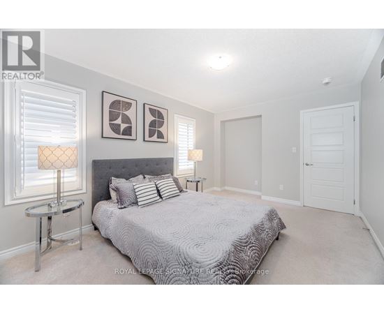 A bedroom with a large bed and two lamps.