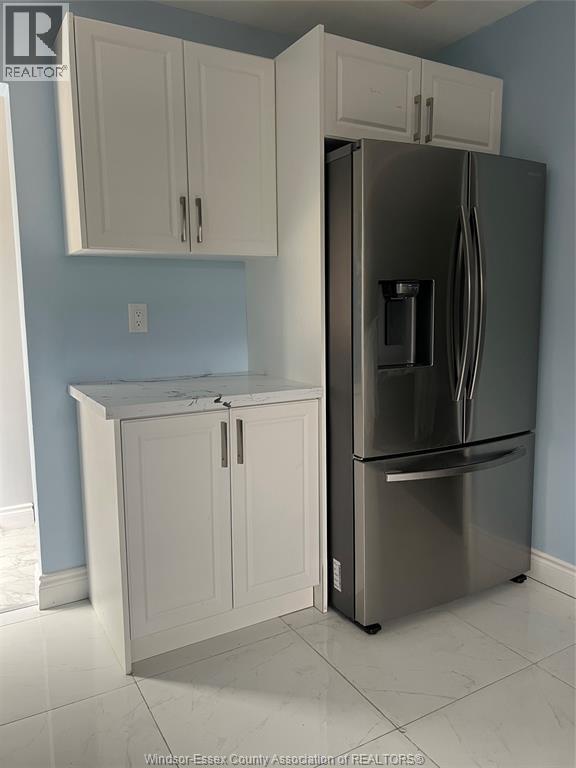 A kitchen with a refrigerator and cabinets.