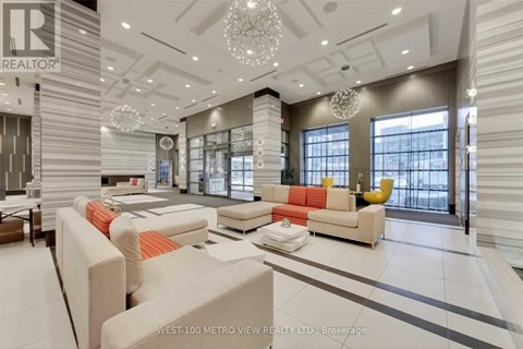 A well-lit, modern living room with a large sofa set and a chandelier.