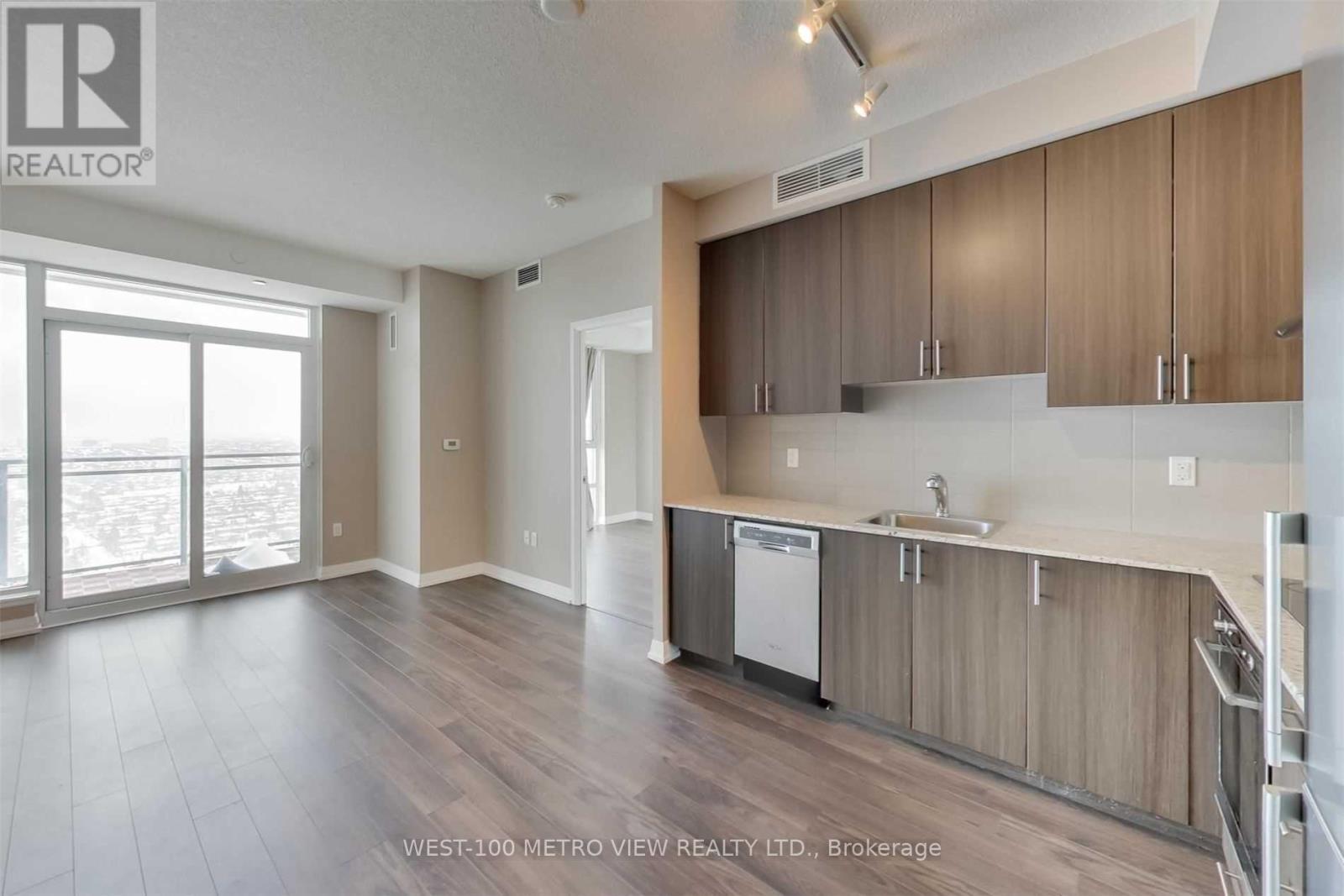 A spacious kitchen with wooden cabinets and a dishwasher.