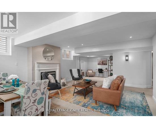 A living room with a fireplace and a dining table with chairs.