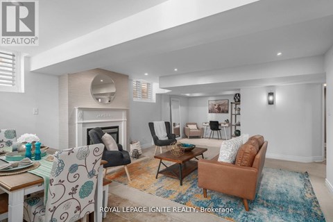 A living room with a fireplace and a dining table with chairs.