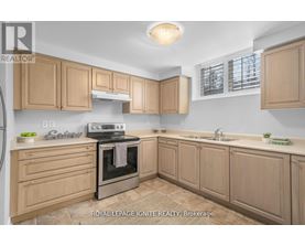 A kitchen with wooden cabinets and a stove top oven.