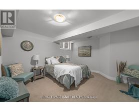 A bedroom with a bed, nightstands, and a chair.