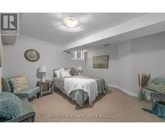 A bedroom with a bed, nightstands, and a chair.