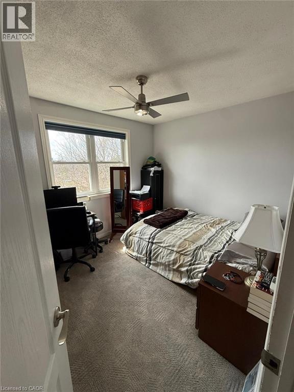A bedroom with a bed, desk, and chair.