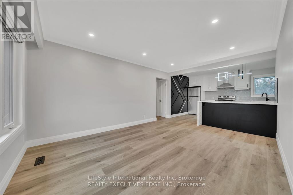 A spacious room with wooden flooring and white walls.